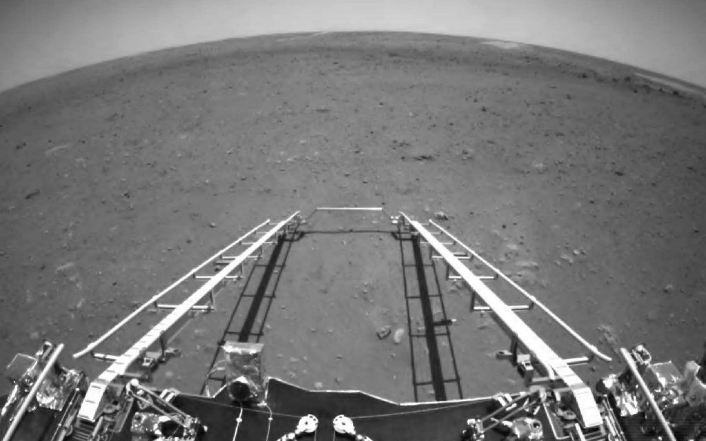 Le rocher chinois Zhurong s'apprête à descendre de l'atterrisseur qui l'a amener sur Mars. La rampe d'accès est déployée face à un terrain plat et quasiment pas accidenté. Un site d'atterrissage morne et désolé comme on a l'habitude d'en avoir avec les missions de la Nasa. © CNSA