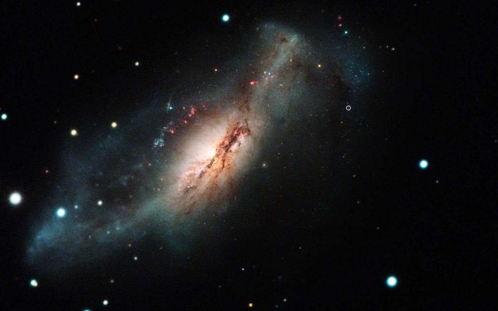 Une image composite formée de photos de l'observatoire de Las Cumbres et du télescope spatial Hubble montrant la supernova à capture d'électrons 2018zd (le cercle, en haut à droite) et sa galaxie hôte NGC 2146 (vers la gauche). © Nasa/STScI/J. DePasquale ; Observatoire de Las Cumbres